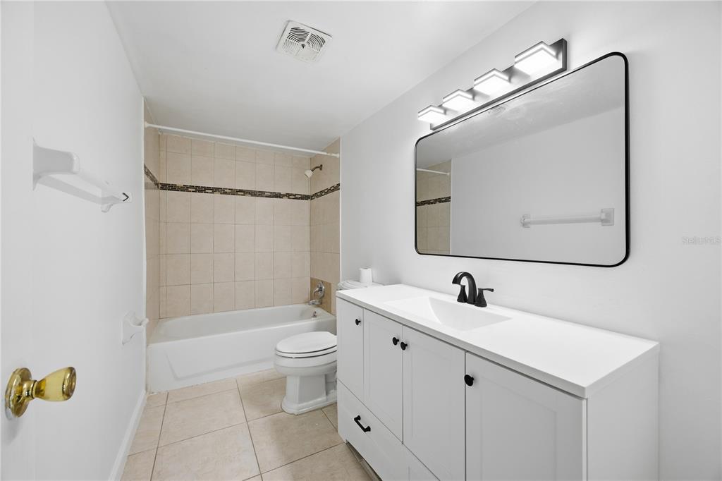 925 West Oak Ridge Road, Unit 925C Orlando, FL 32809 - Photo 11 of 15 a bathroom with a double vanity sink mirror double and bathtub