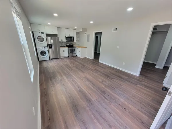 a view of a kitchen with a sink and dishwasher a refrigerator with wooden floor