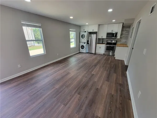 a view of kitchen with refrigerator stove and wooden floor