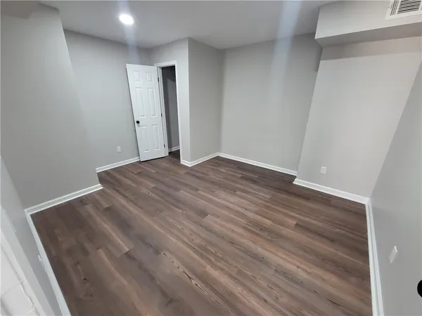 a view of an empty room with wooden floor