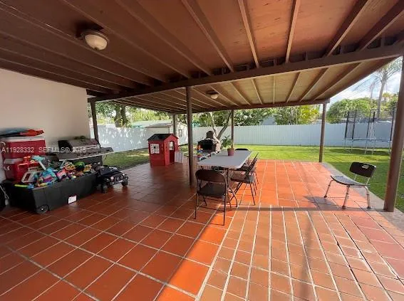 a view of a chairs and tables in the patio next to a yard
