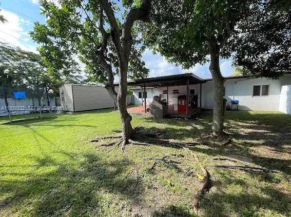a view of a house with backyard and tree