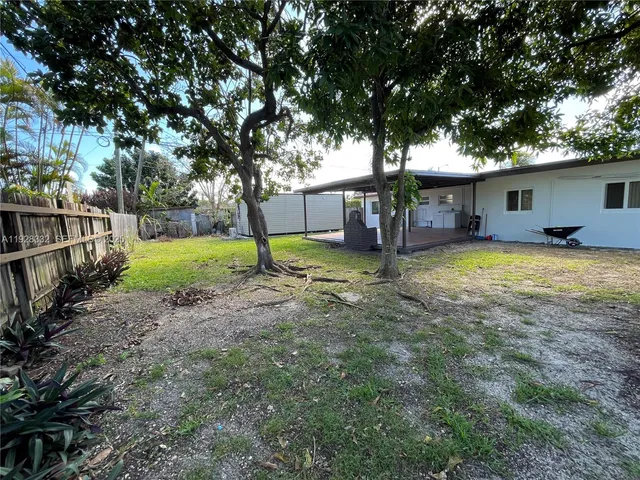 a view of a house with a yard and tree