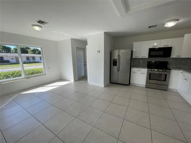 a kitchen with stainless steel appliances a refrigerator and a stove top oven