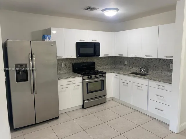 a kitchen with cabinets stainless steel appliances and a counter space