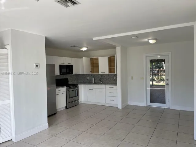 a large kitchen with cabinets and stainless steel appliances