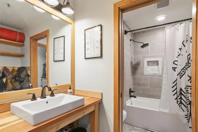 a bathroom with a sink mirror and a bathtub