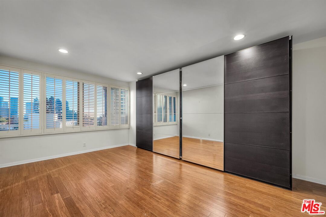 865 Comstock Avenue, Unit 4C Los Angeles, CA 90024 - Photo 20 of 26 a view of an empty room with wooden floor and a window