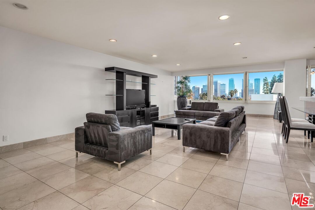 865 Comstock Avenue, Unit 4C Los Angeles, CA 90024 - Photo 9 of 26 a living room with couches and a dining table with kitchen view
