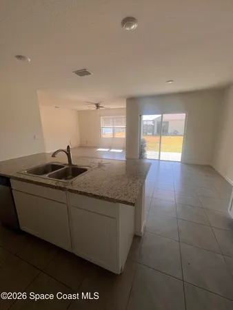 a view of a living room with kitchen and furniture