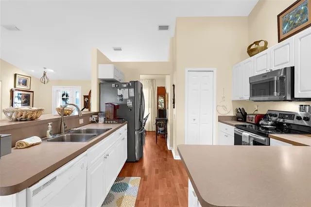 a large kitchen with a sink and stainless steel appliances