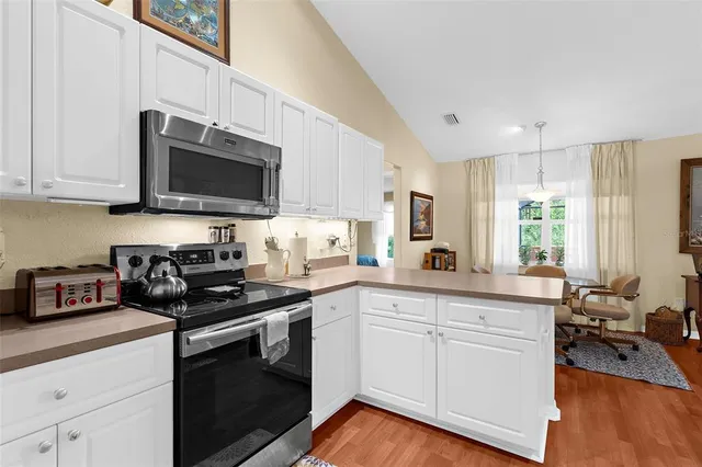 a kitchen with cabinets appliances a sink and a counter top space