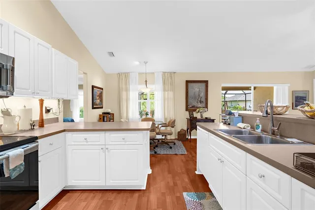 a large kitchen with a lot of counter space and wooden floor