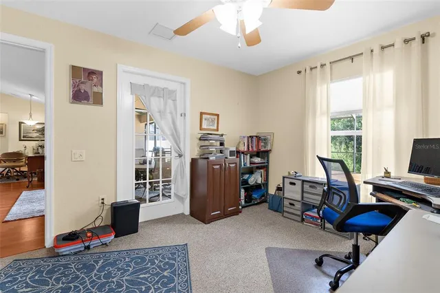 a view of a livingroom with workspace and a window
