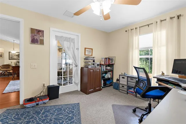 a view of a livingroom with workspace and a window