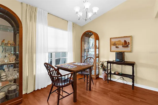 a dining room with furniture a chandelier and wooden floor