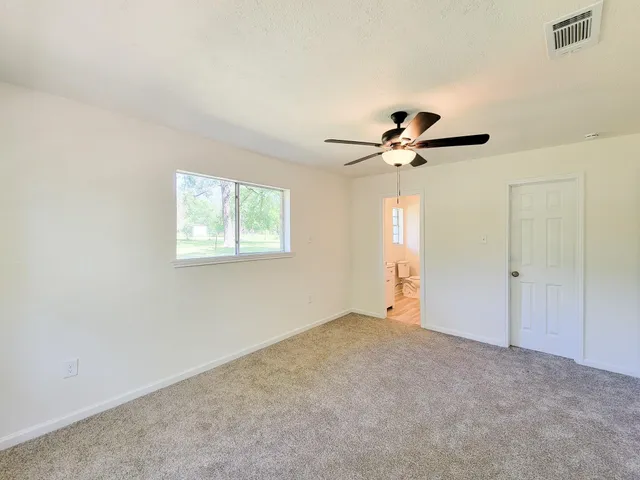 a view of an empty room with a ceiling fan