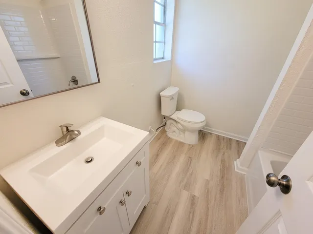 a bathroom with a sink a toilet and mirror
