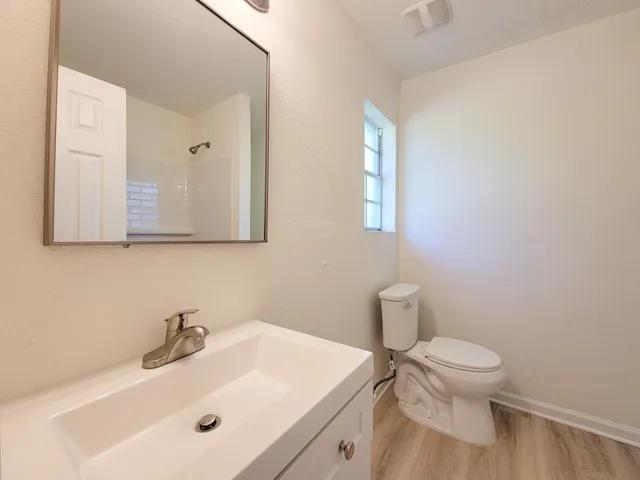 a bathroom with a sink a toilet and a mirror