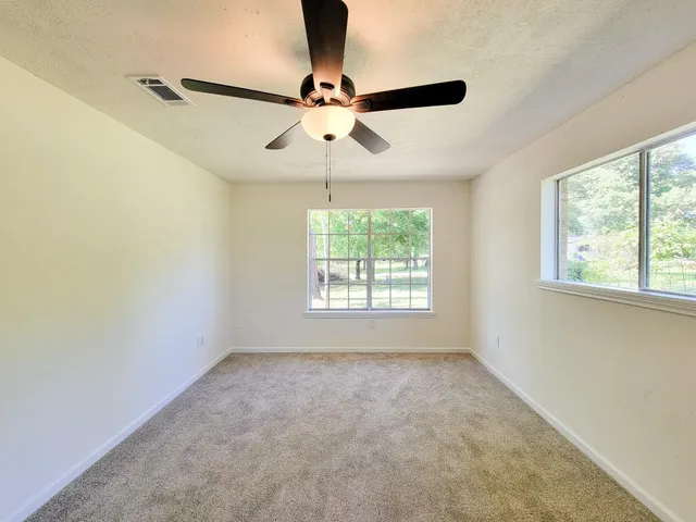 a view of room with a window and a ceiling fan