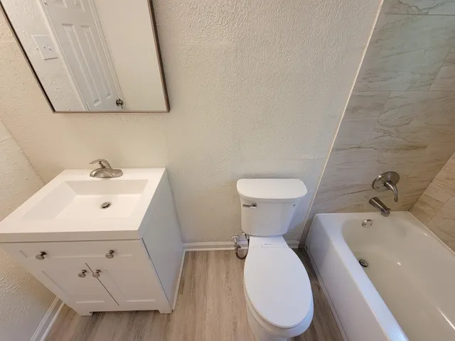 a white toilet sitting next to a white sink