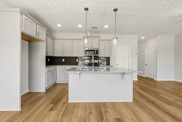a kitchen with kitchen island stainless steel appliances a refrigerator sink and wooden cabinets