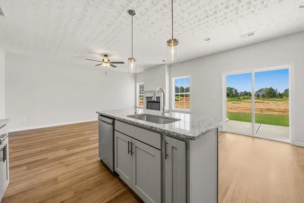a view of a kitchen with a sink and wooden floor