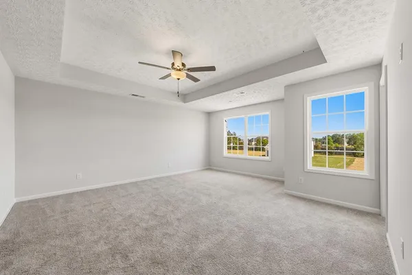 an empty room with windows and ceiling fan