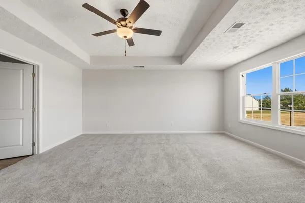 an empty room with fan and windows