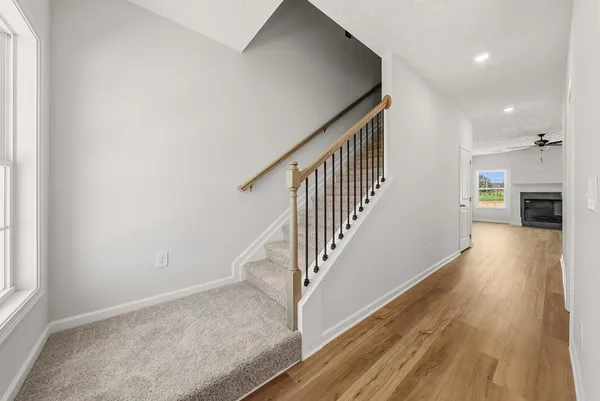 a view of a hallway with wooden floor and staircase
