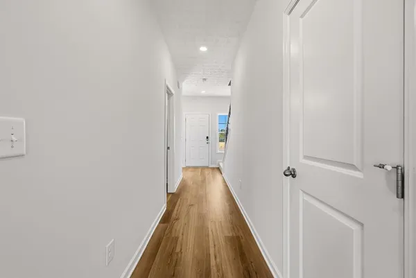 a view of a hallway with wooden floor and staircase