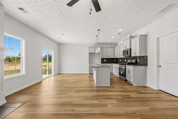 a view of kitchen with granite countertop cabinets and refrigerator