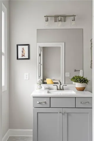 a bathroom with a granite countertop bathtub shower sink vanity and toilet