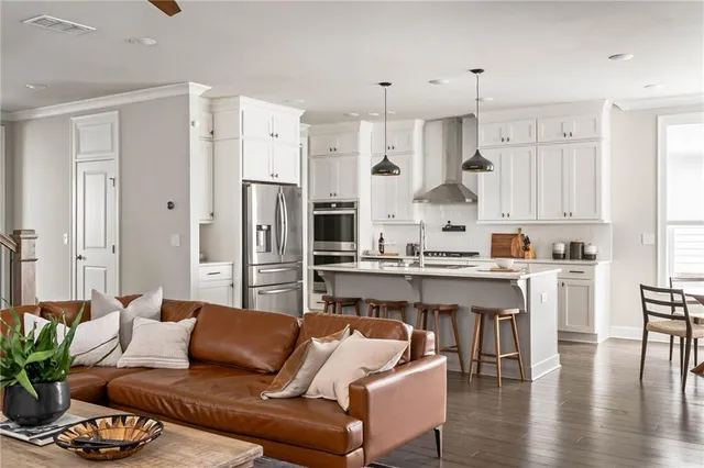 a living room with stainless steel appliances kitchen island granite countertop furniture and a view of kitchen