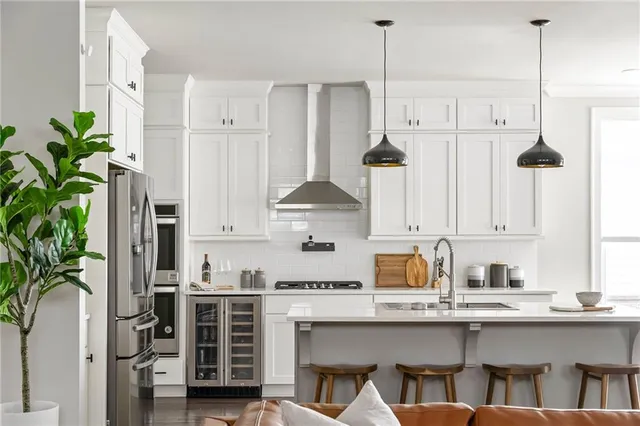 a kitchen with stainless steel appliances a table and chairs in it