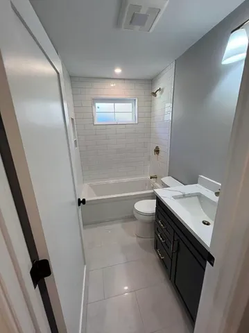 a bathroom with a sink a toilet a mirror and a bathtub