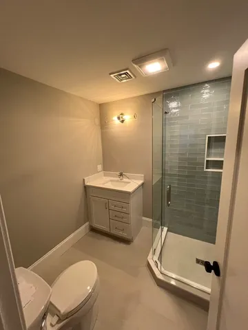 a bathroom with a sink a toilet and shower