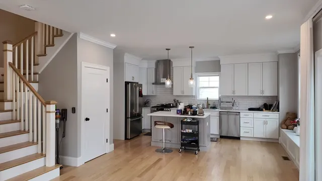 a kitchen with a sink a stove a refrigerator cabinets and wooden floor