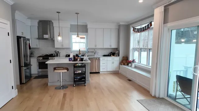 a kitchen with kitchen island granite countertop a sink cabinets and stainless steel appliances