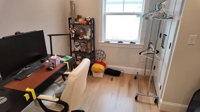 a view of a workspace with furniture and a window