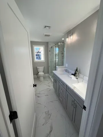 a spacious bathroom with a sink a toilet and a mirror