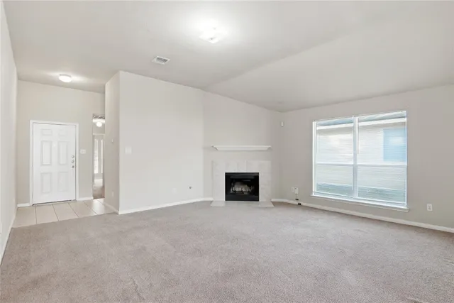 an empty room with fireplace and windows