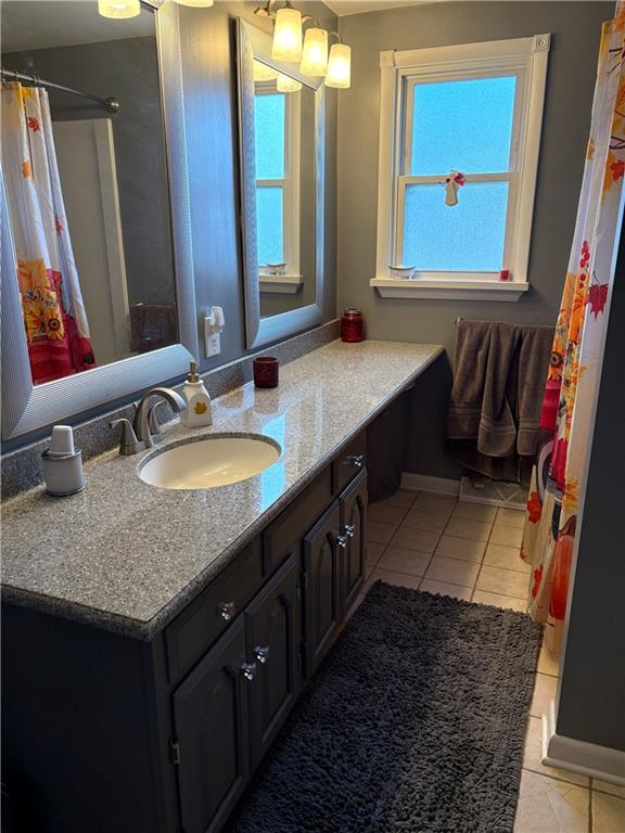 5719 Halchess Street Pittsburgh, PA 15207 - Photo 16 of 25 a bathroom with a granite countertop sink a mirror and a bathtub