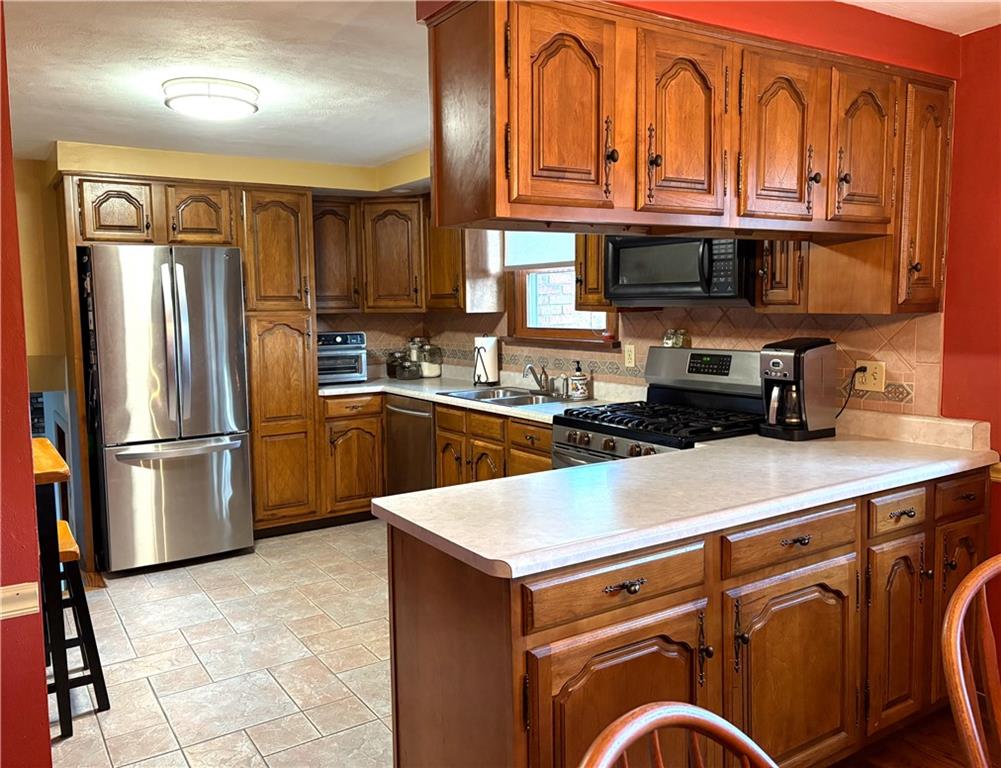 5719 Halchess Street Pittsburgh, PA 15207 - Photo 8 of 25 a kitchen with stainless steel appliances granite countertop a refrigerator a sink and a stove