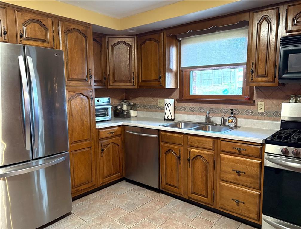 5719 Halchess Street Pittsburgh, PA 15207 - Photo 9 of 25 a kitchen with stainless steel appliances granite countertop a refrigerator stove and sink