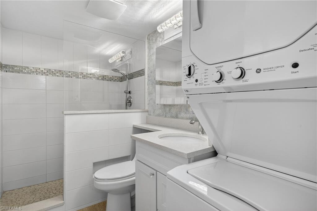 5900 Bonita Beach Road Southwest, Unit 1602 Bonita Springs, FL 34134 - Photo 13 of 26 Full bathroom with a walk in shower, vanity, and stacked washer and clothes dryer
