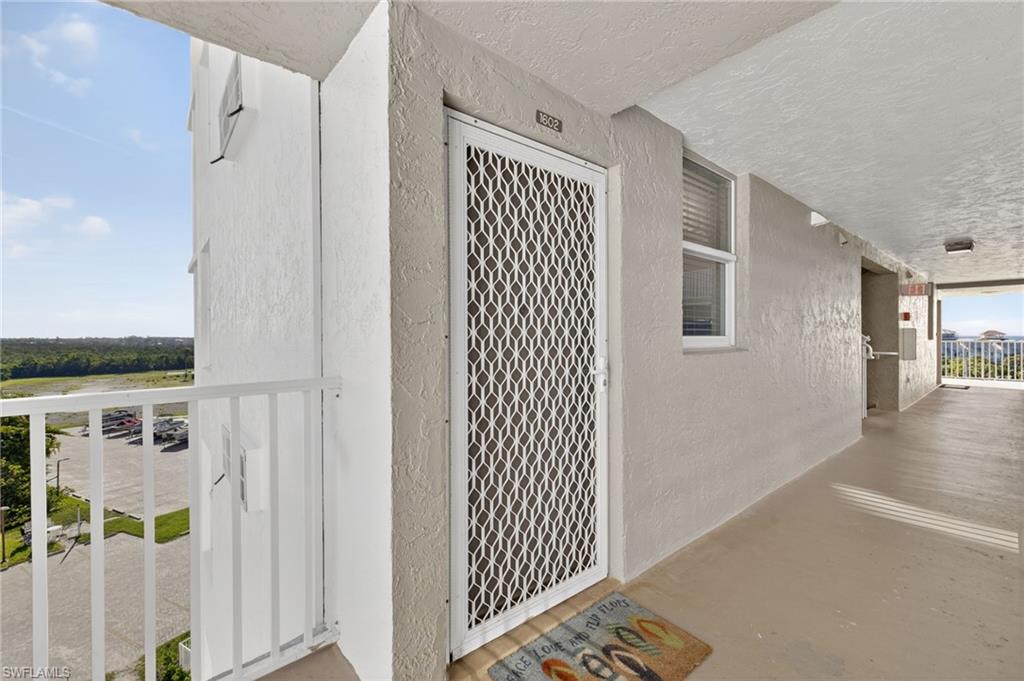 5900 Bonita Beach Road Southwest, Unit 1602 Bonita Springs, FL 34134 - Photo 4 of 26 View of exterior entry featuring stucco siding