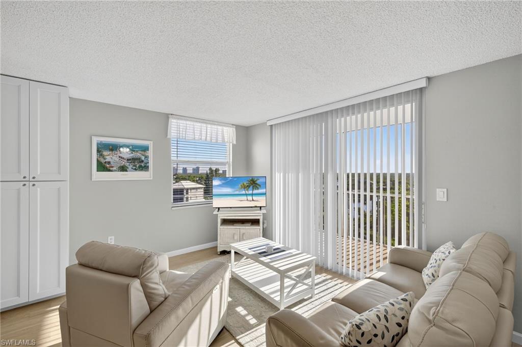5900 Bonita Beach Road Southwest, Unit 1602 Bonita Springs, FL 34134 - Photo 5 of 26 Living room with light wood finished floors and a textured ceiling