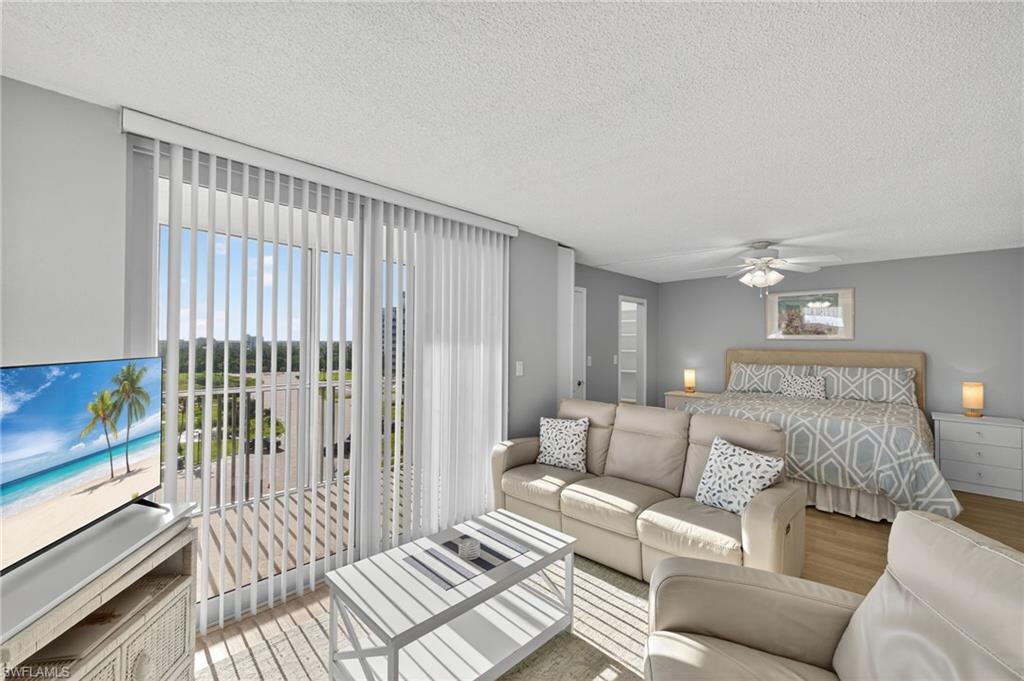 5900 Bonita Beach Road Southwest, Unit 1602 Bonita Springs, FL 34134 - Photo 7 of 26 Bedroom with wood finished floors, a textured ceiling, access to outside, and a ceiling fan