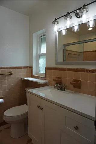 a bathroom with a granite countertop sink a toilet and a mirror